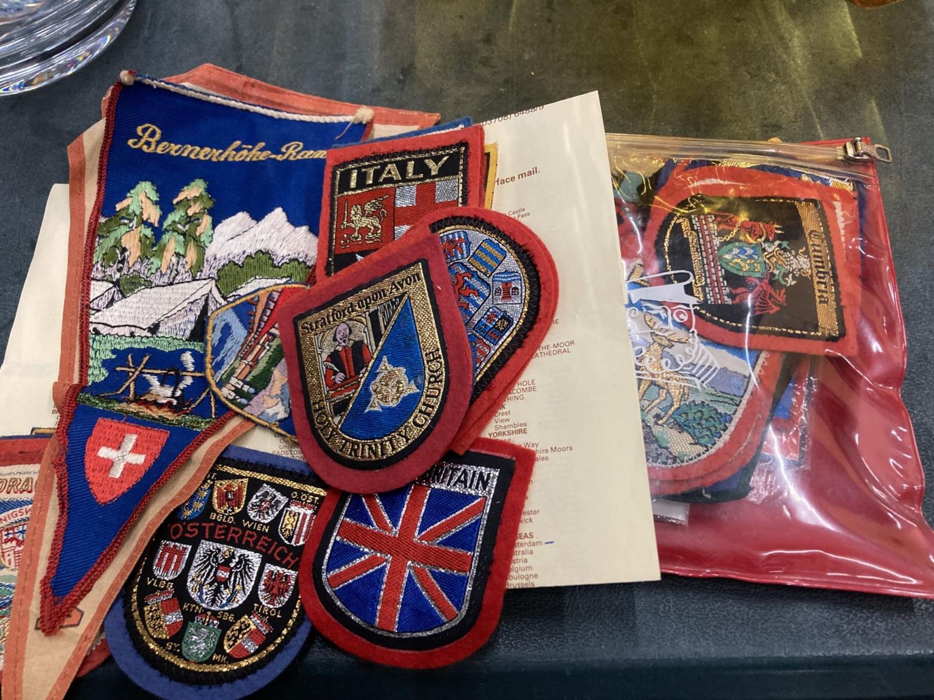 A LARGE QUANTITY OF CLOTH BADGES AND PENNANTS OF VARIOUS COUNTRIES
