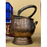 A FIREMAN'S HELMET STYLE BEATEN COPPER COAL SCUTTLE WITH BRASS HANDLE