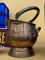 A FIREMAN'S HELMET STYLE BEATEN COPPER COAL SCUTTLE WITH BRASS HANDLE