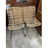 A PAIR OF WICKER AND BAMBOO DINING CHAIRS ON BLACK METALWARE FRAMES