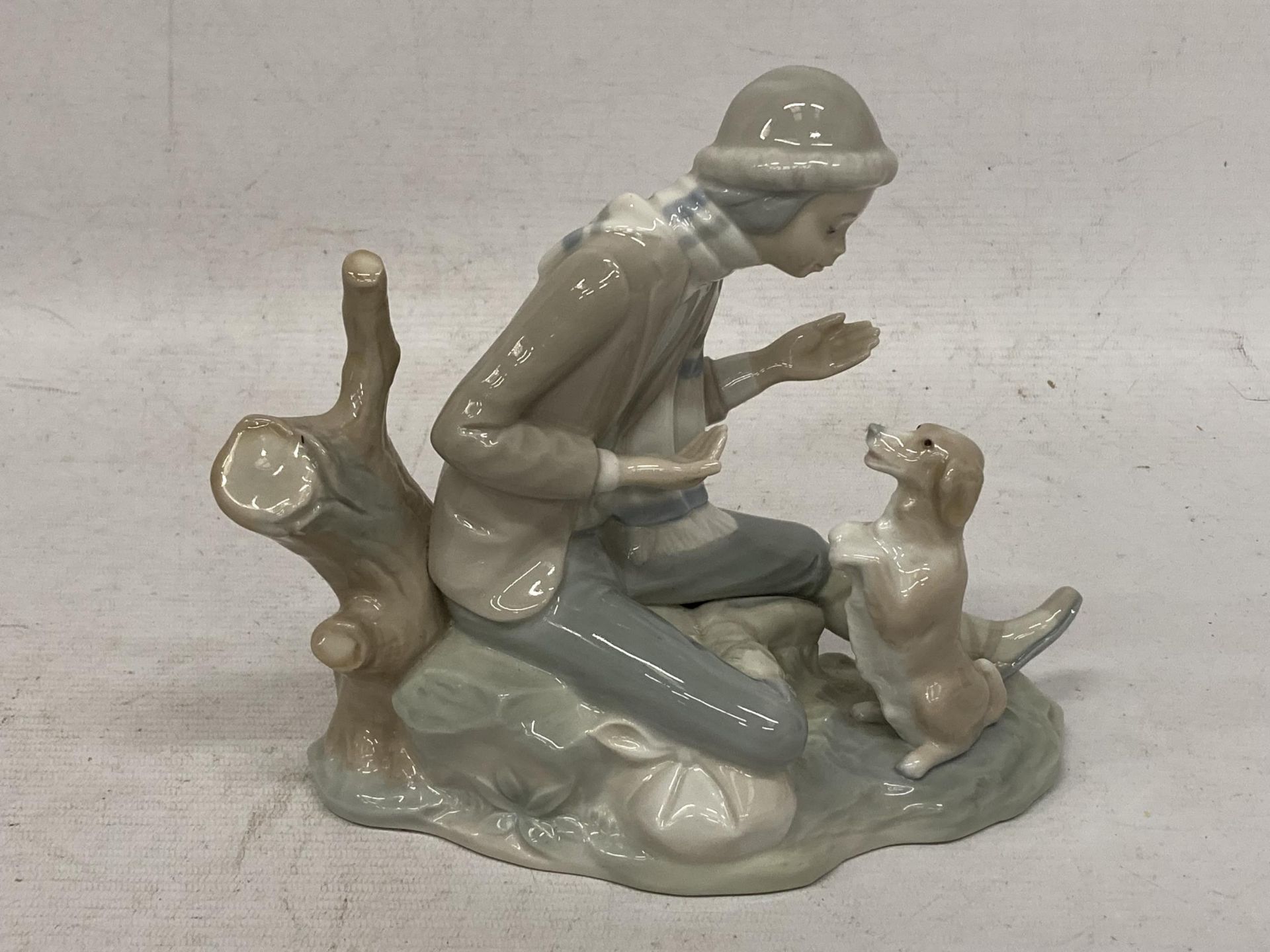 A NAO LLADRO FIGURE OF A BOY WITH DOG