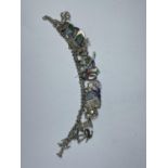 A SILVER CHARM BRACELET WITH TWENTY FOUR VARIOUS CHARMS WEIGHT 48.2 GRAMS