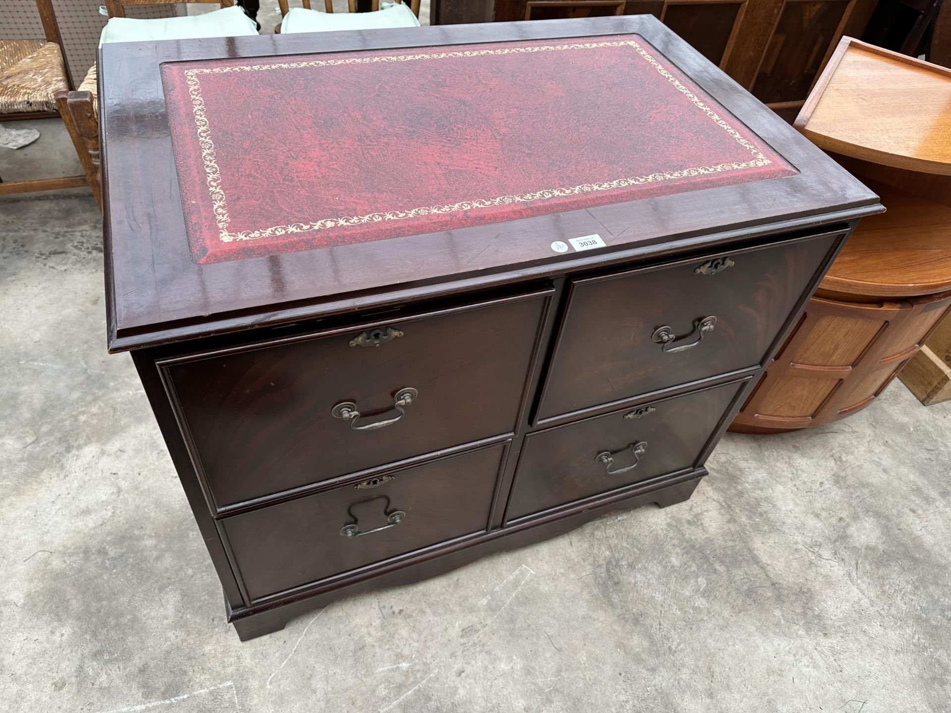 A MAHOGANY AND RED LEATHER TOPPED FOUR DRAWER CABINET