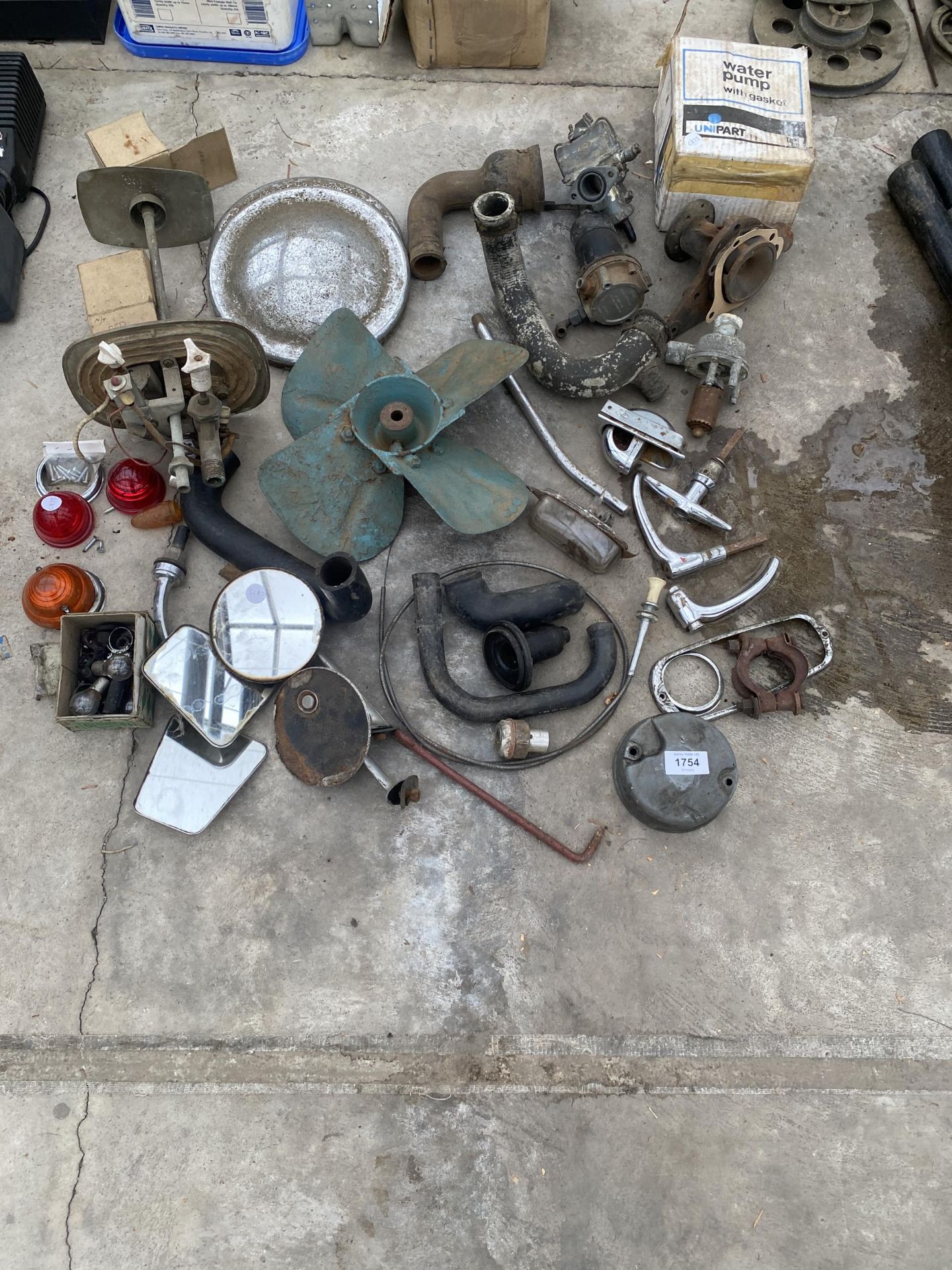 AN ASSORTMENT OF VEHICLE SPARES TO INCLUDE HANDLES, MIRRORS, FANS AND HUB CAPS ETC