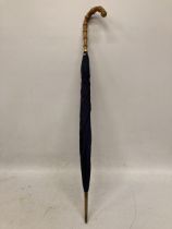 A VINTAGE BAMBOO HANDLED PARASOL WITH YELLOW METAL BAND STAMPED 18CT P.G