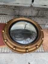 A GILT FRAMED PORTHOLE STYLE MIRROR