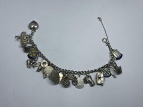A SILVER CHARM BRACELET WITH NINETEEN VARIOUS CHARMS WEIGHT 49 GRAMS
