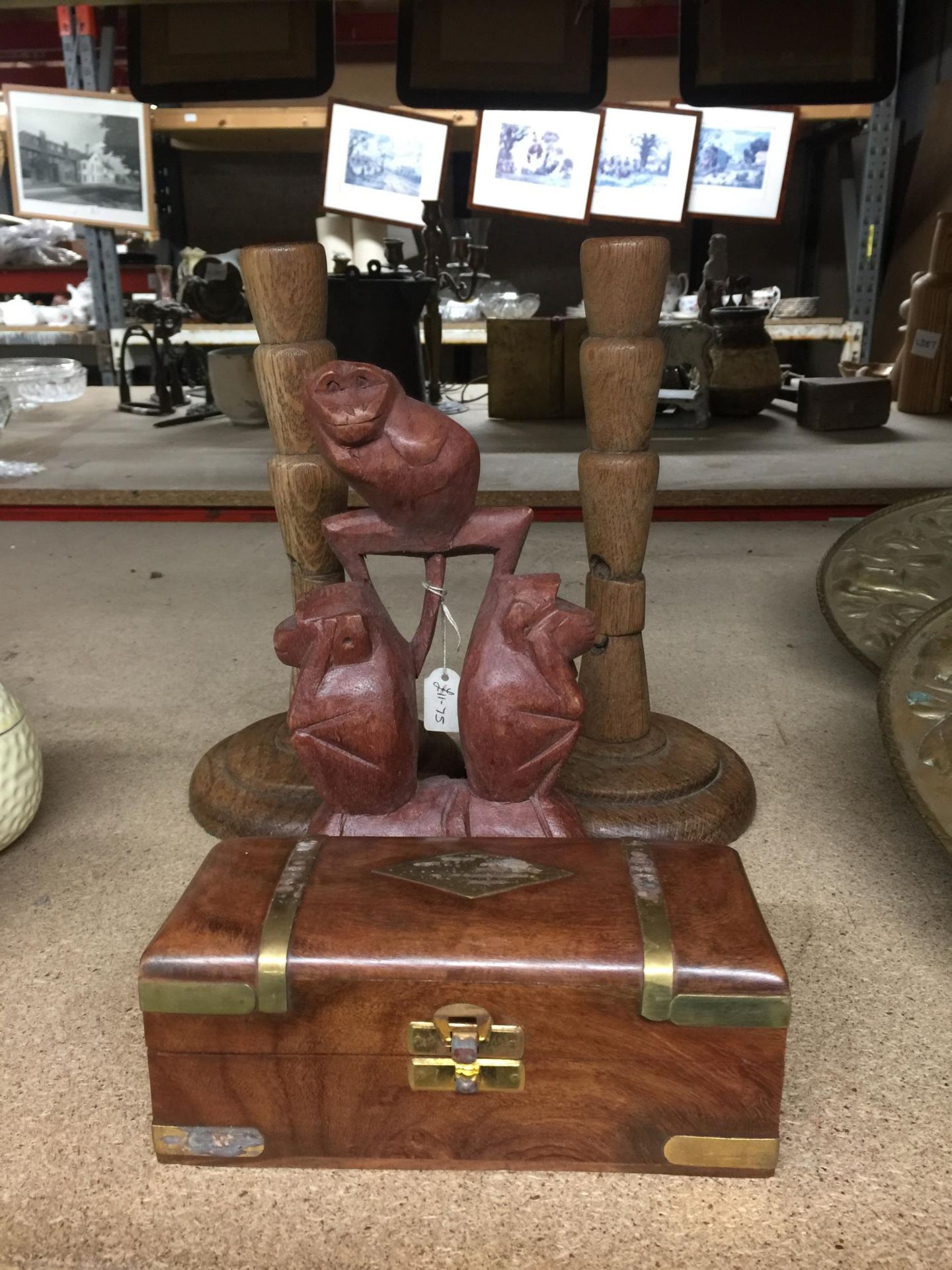 FOUR WOODEN ITEMS - BRASS BOUND BOX, PAIR OF CANDLESTICKS AND MONKEY CARVING