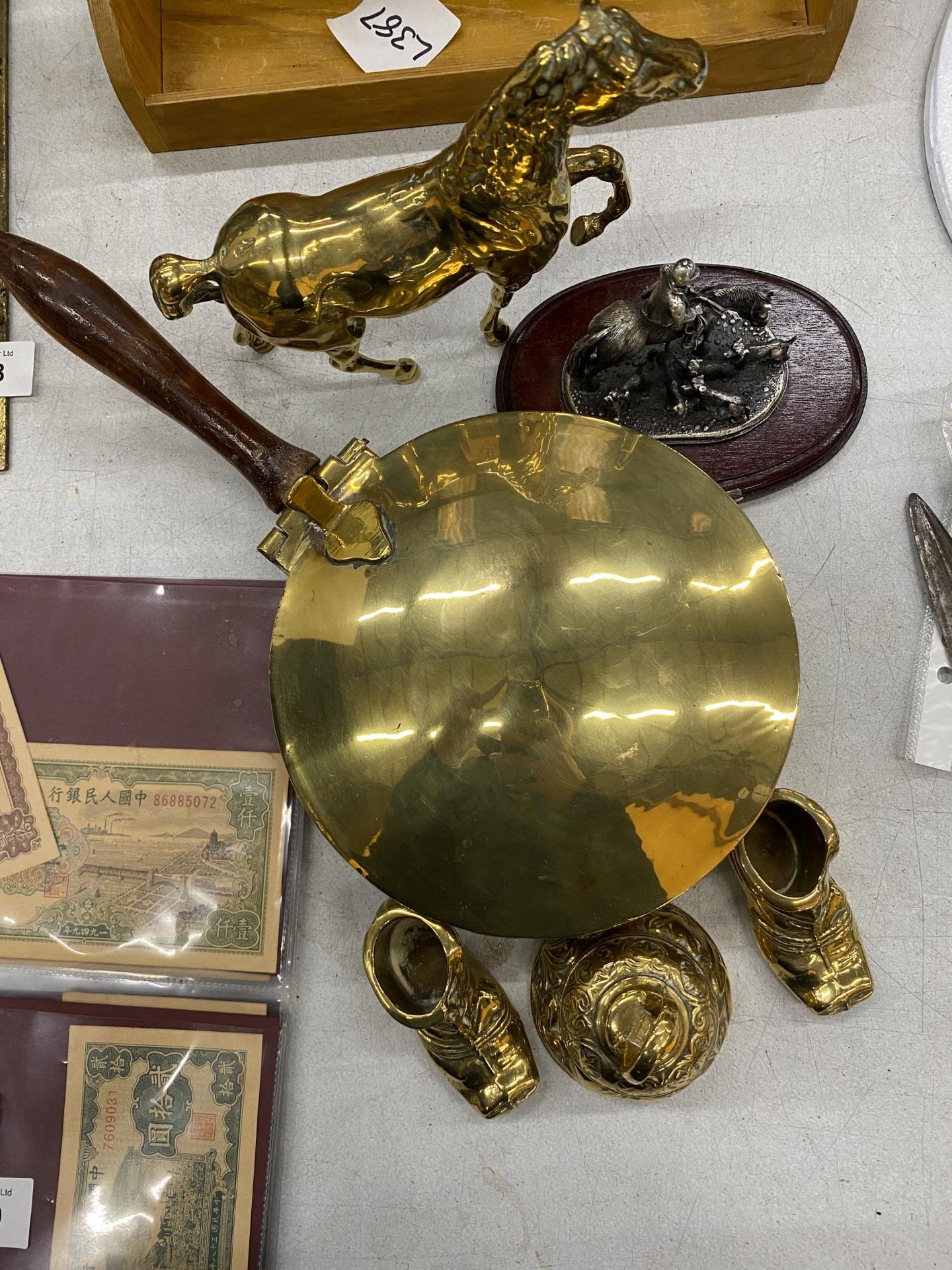 A QUANTITY OF BRASSWARE TO INCLUDE A LIDDED PAN, HORSE, SHOES AND A BELL PLUS A SMALL PEWTER TABLEAU