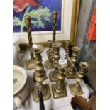 A LARGE QUANTITY OF VINTAGE BRASS CANDLESTICKS