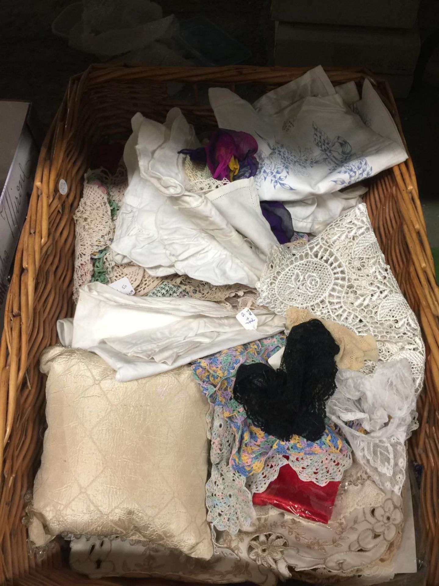 A QUANTITY OF VINTAGE DOILIES, PLACEMATS, ETC IN A WICKER BASKET
