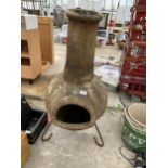 A RECONSTITUTED STONE GARDEN CHIMENEA WITH METAL STAND (A/F CRACKED THROUGH THE MIDDLE)