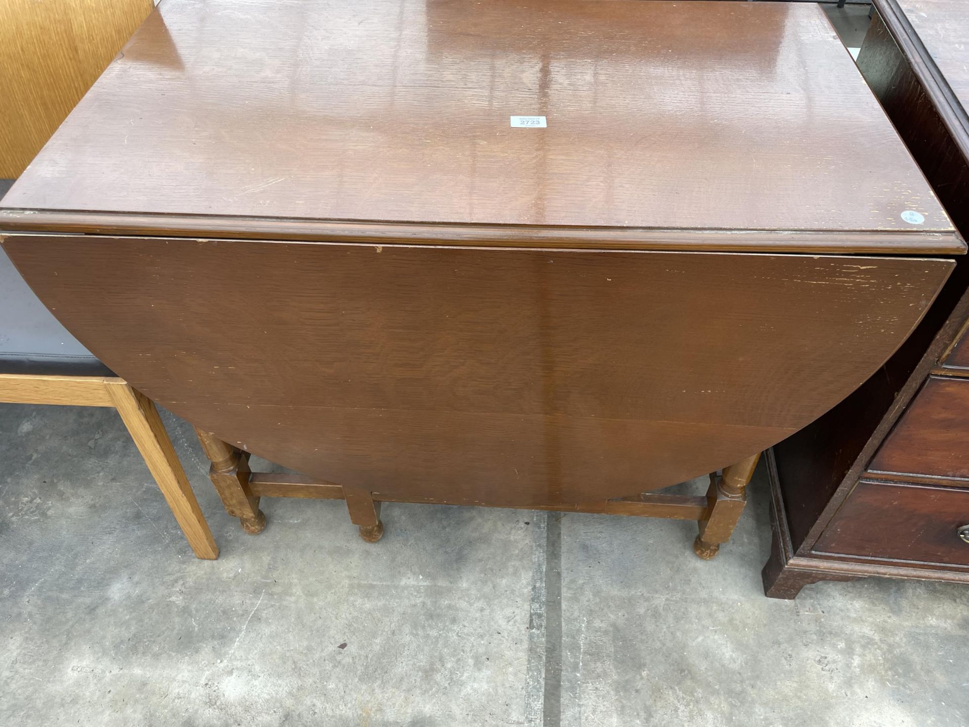 A MID 20TH CENTURY OAK GATELEG DINING TABLE ON TURNED LEGS