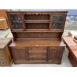 A REPRODUCTION OAK DRESSER WITH THREE DRAWERS TO THE BASE, TWO LINENFOLD DOORS AND PLATE RACK