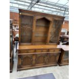 AN OAK GLAZED AND LEADED OLD CHARM STYLE BOOKCASE ON BASE, WITH THREE CUPBOARDS AND THREE DRAWERS TO
