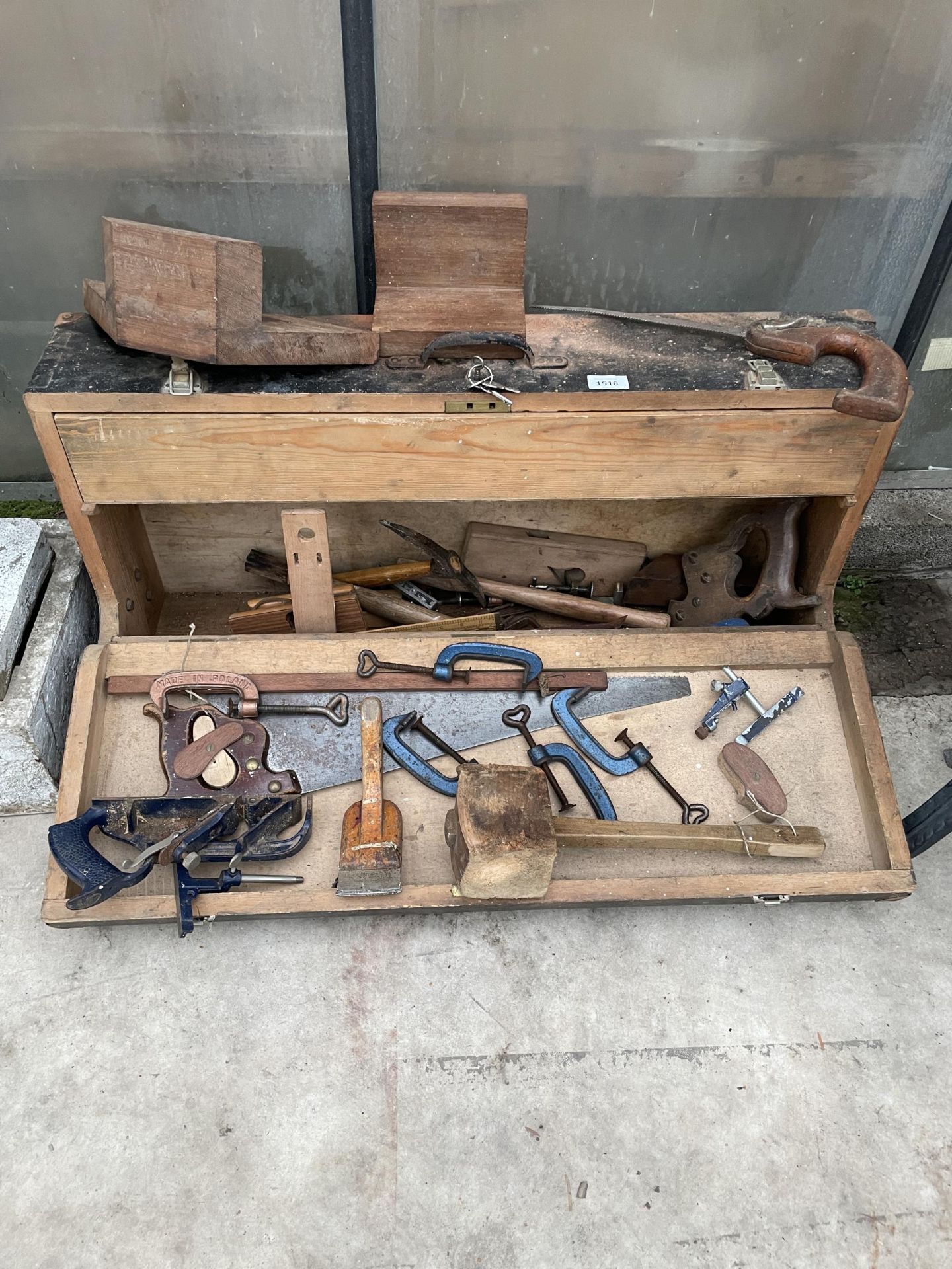 A VINTAGE WOODEN JOINERS CHEST WITH AN ASSORTMENT OF TOOLS TO INCLUDE G CLAMPS, WOOD PLANES AND SAWS