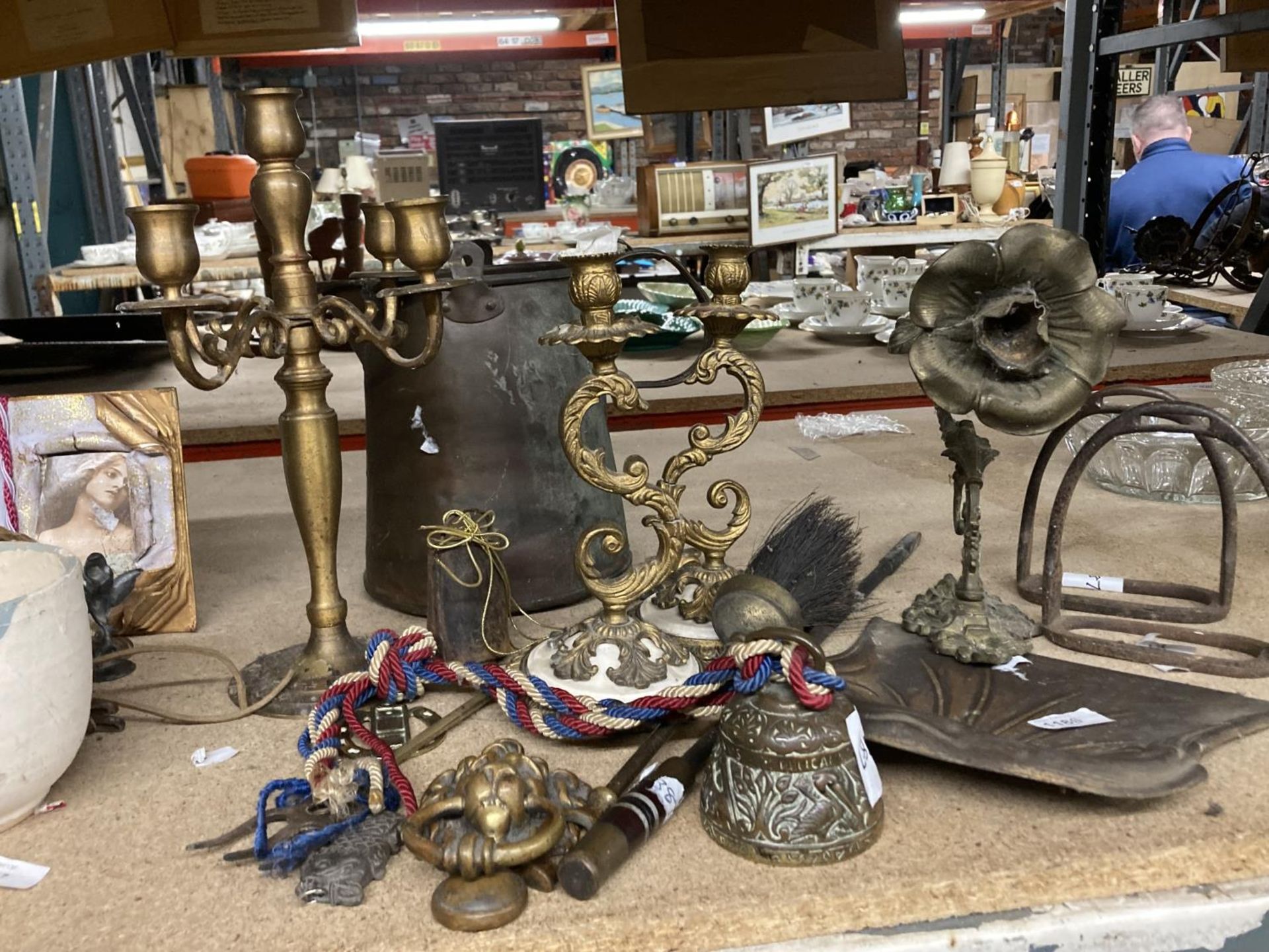 A QUANTITY OF BRASSWARE TO INCLUDE A CANDLEABRA, A BELL, LION DOOR KNOCKER, COW BELL, ETC.,