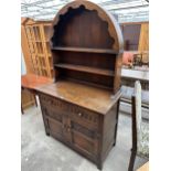 A JAYCEE OAK DRESSER WITH UPPER ROUNDED PLATE RACK AND LOWER DRAWERS AND DOORS