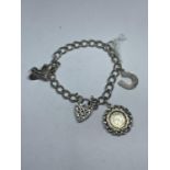 A SILVER CHARM BRACELET WITH THREE CHARMS AND A DECORATIVE HEART PADLOCK WEIGHT 25.5 GRAMS