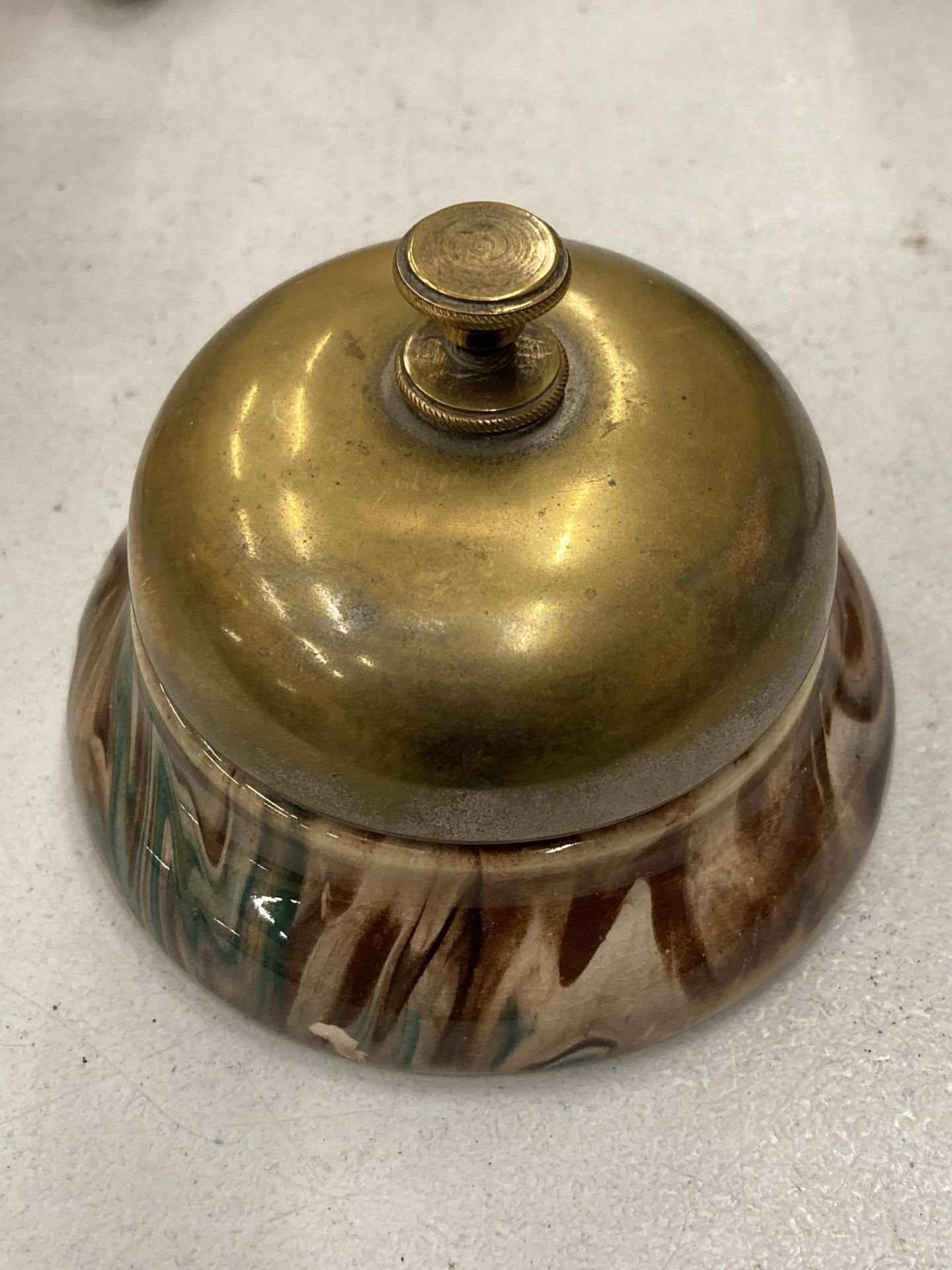 A VINTAGE BRASS AND POTTERY DESK BELL