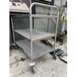 A THREE TIER STAINLESS STEEL FOUR WHEELED TROLLEY