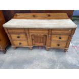 A VICTORIAN PINE KITCHEN SIDE BOARD WITH SYCAMORE TOP, ENCLOSING SEVEN DRAWERS AND CENTRAL CUPBOARD,