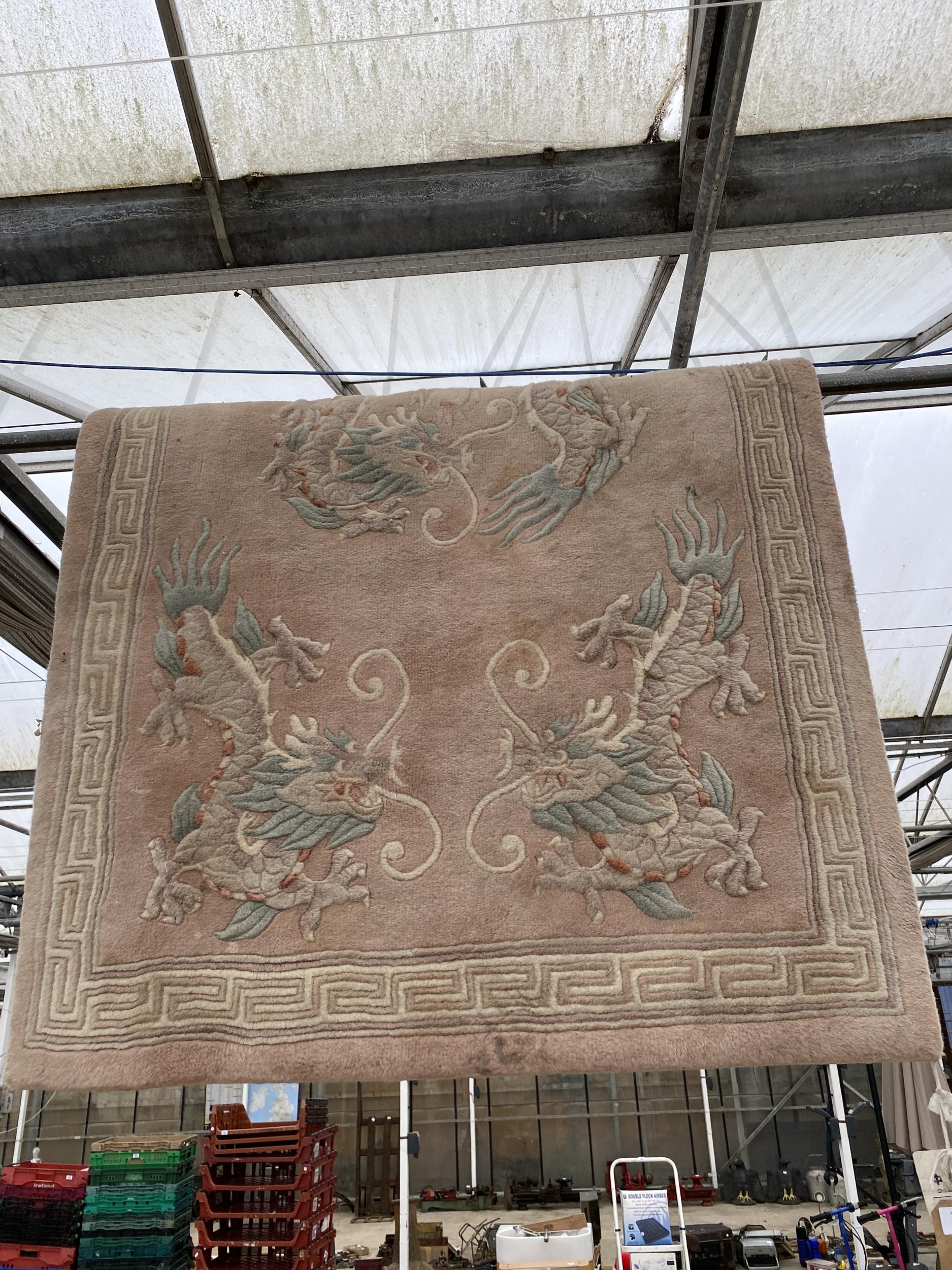 A PINK RUG WITH ORIENTAL DRAGON DESIGN