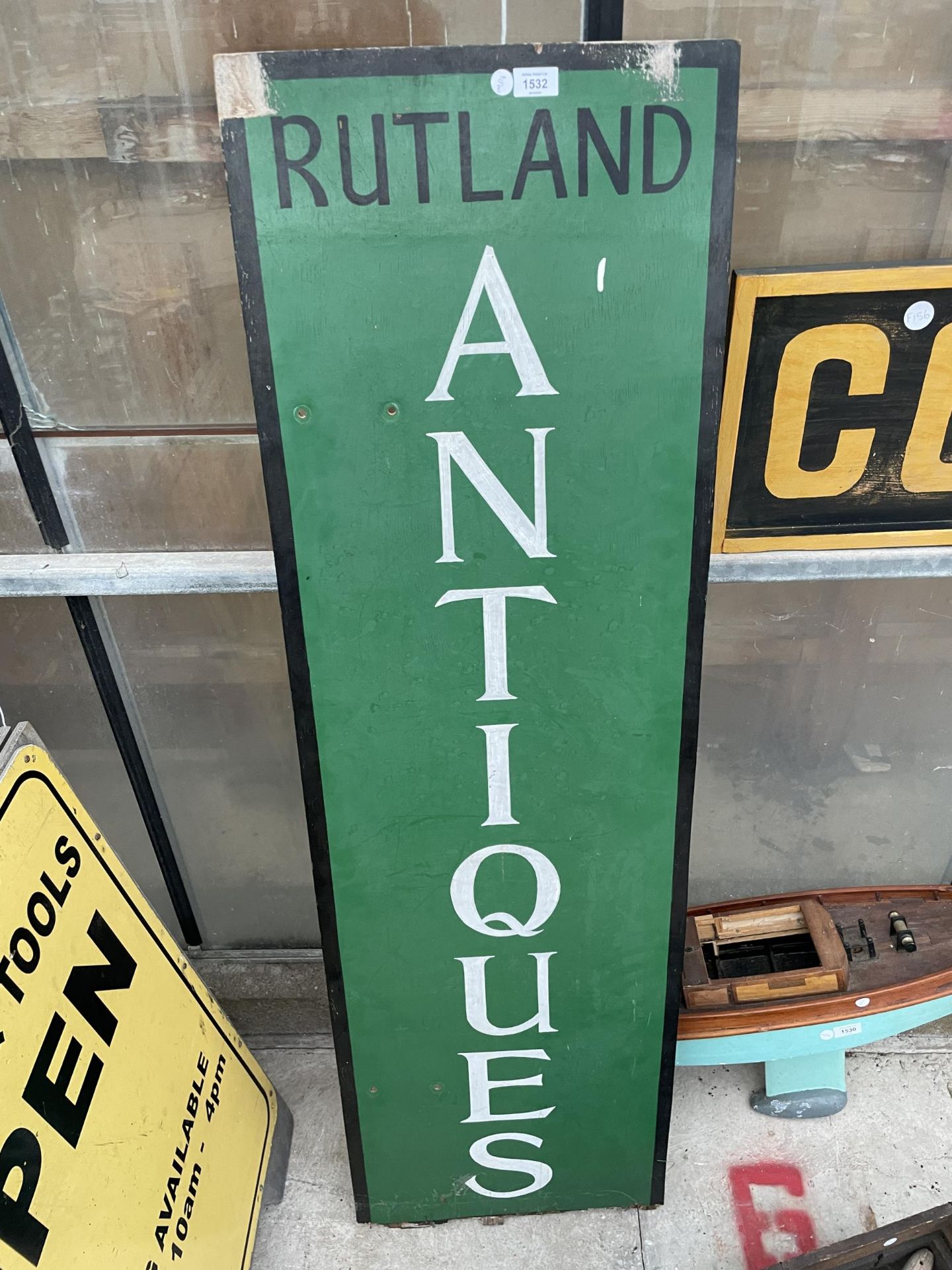 A WOODEN HAND PAINTED 'RUTLAND ANTIQUES' SIGN