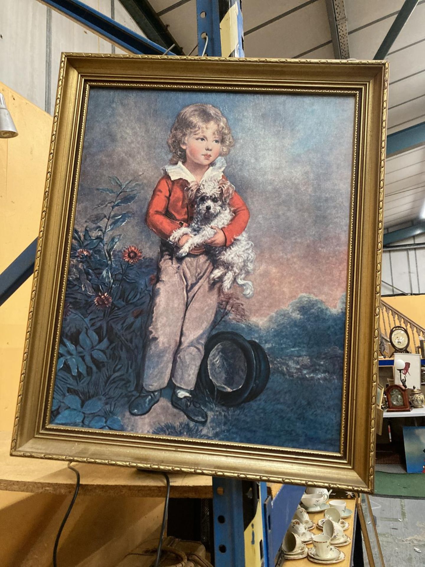A FRAMED PAINTING OF A BOY AND HIS DOG ON CANVAS, 49CM X 59CM