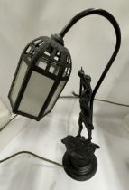 A SPELTER FIGURAL TABLE LAMP AND SHADE DEPICTING A LADY ON A ROCK