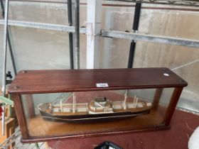 A MODEL OF A SHIP IN A GLASS DISPLAY CABINET