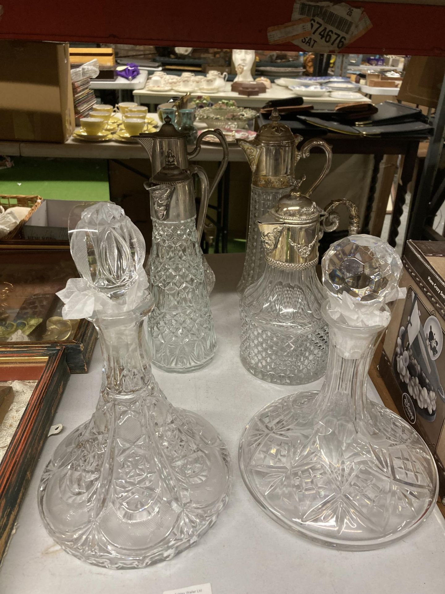 A GROUP OF FOUR SILVER PLATED AND CUT GLASS CLARET JUGS AND TWO FURTHER DECANTERS