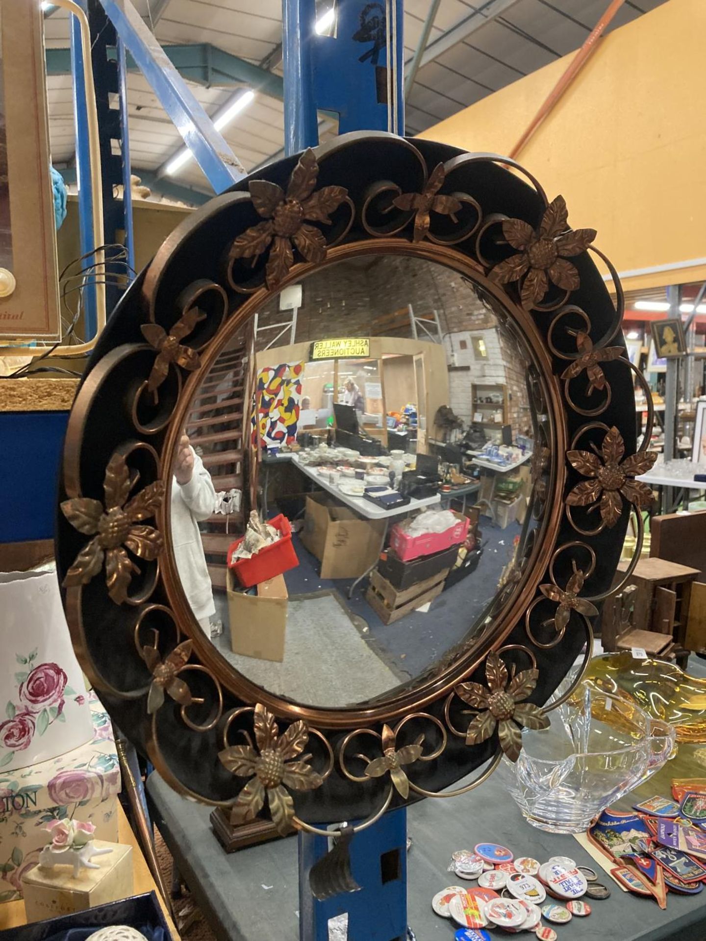 A VINTAGE ROUND METAL MIRROR WITH BRASS FLORAL DECORATION, DIAMETER 48CM