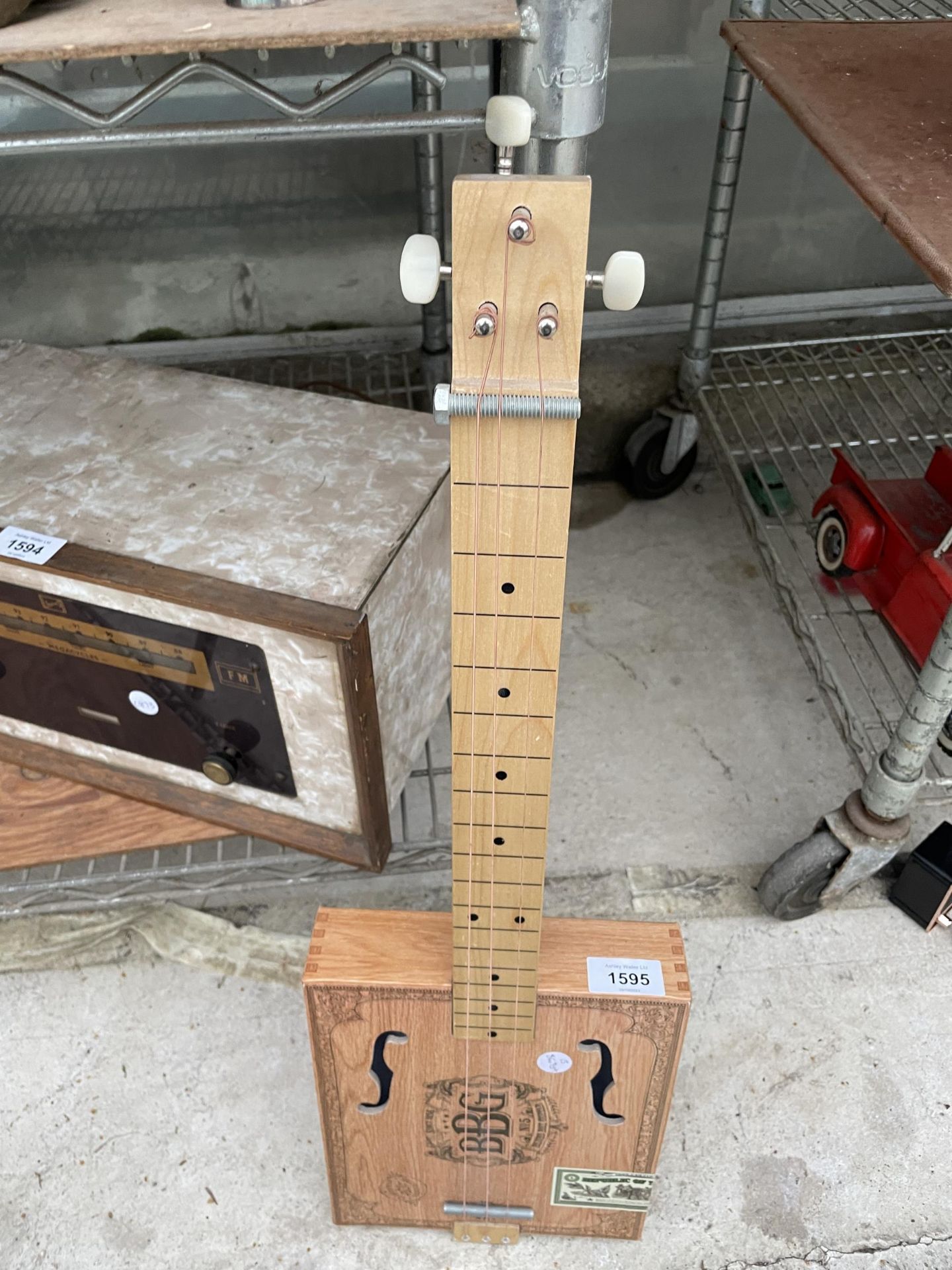 A SCRATCH BUILT THREE STRING INSTRUMENT FORMED FROM A CIGAR BOX