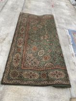 A LARGE GREEN PATTERNED RUG