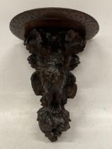 A MID 19TH CENTURY HEAVILY CARVED BLACK FOREST WALL SCONCE