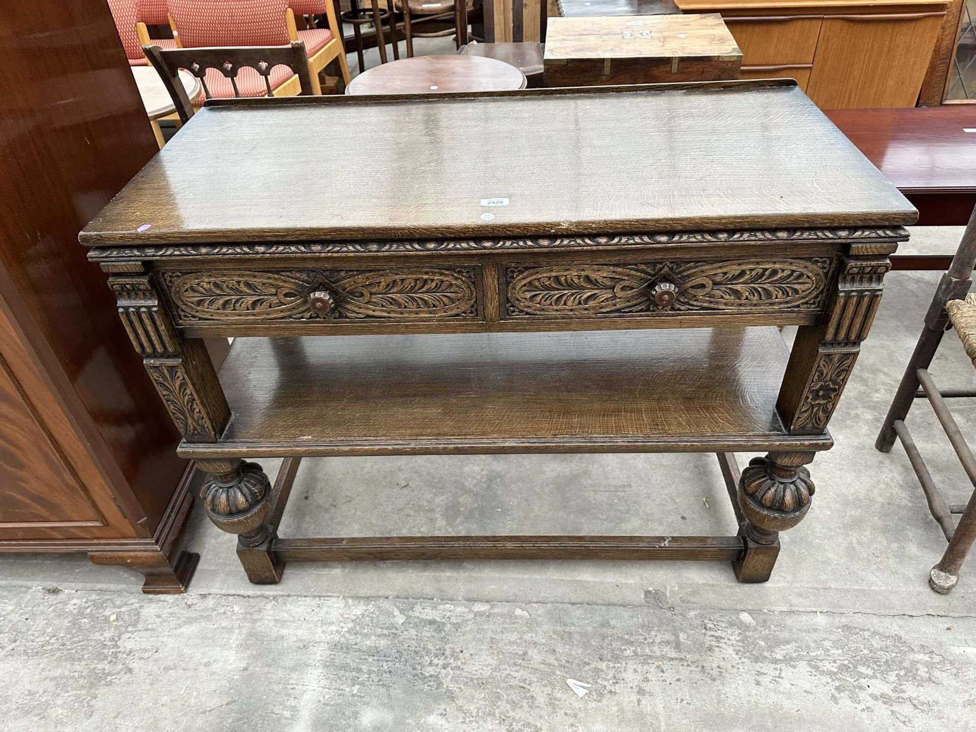 A JACOBEAN STYLE OAK BERICK FURNITURE SIDE-TABLE ENCLOSING TWO DRAWERS ON OPEN BASE WITH POT