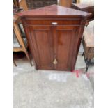 A 19TH CENTURY MAHOGANY CORNER CUPBOARD WITH TWO PANELED DOORS, 35" WIDE