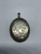 A MARKED SILVER DECORATIVE OVAL LOCKET WEIGHT 7.1 GRAMS