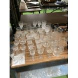 A LARGE QUANTITY OF GLASSWARE TO INCLUDE WINE GLASSES, SHERRY GLASSES, SHOT GLASSES, ETC.,