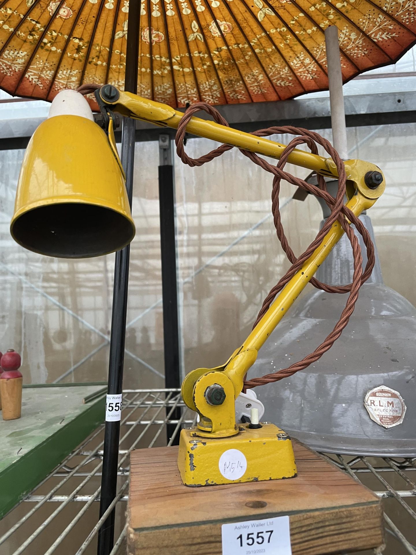 A RETRO YELLOW ANGLE POISE STYLE LAMP ON A WOODEN BASE