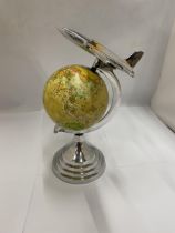 A DESK GLOBE WITH CHROME EFFECT BASE AND AEROPLANE DESIGN