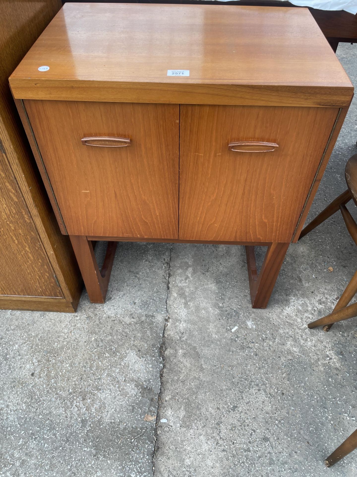 A RETRO TEAK REMPLOY TWO DOOR CABINET ON OPEN BASE, 23.5" WIDE