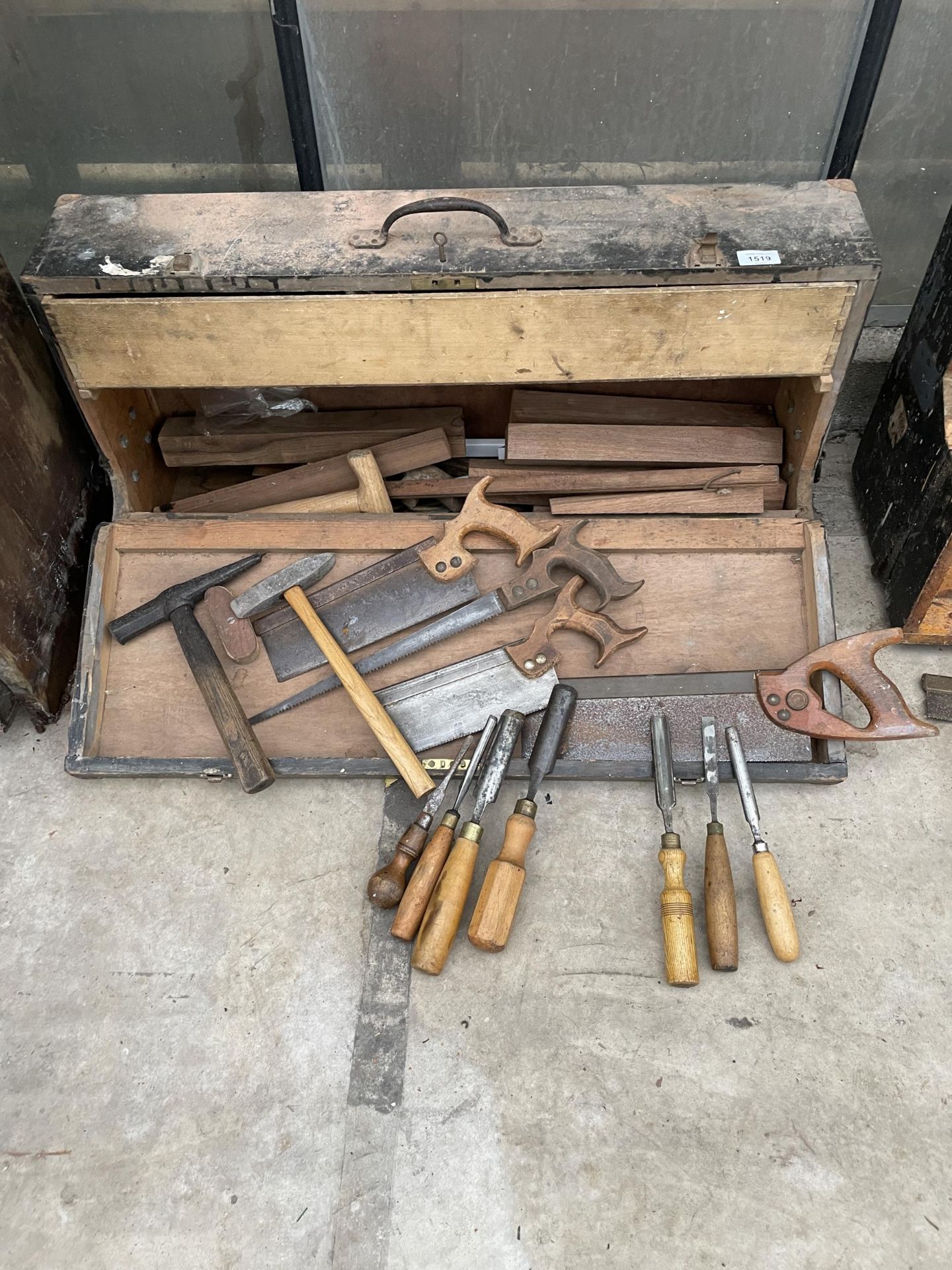 A VINTAGE WOODEN JOINERS CHEST WITH AN ASSORTMENT OF TOOLS TO INCLUDE LATHE CHISELS, SAWS AND
