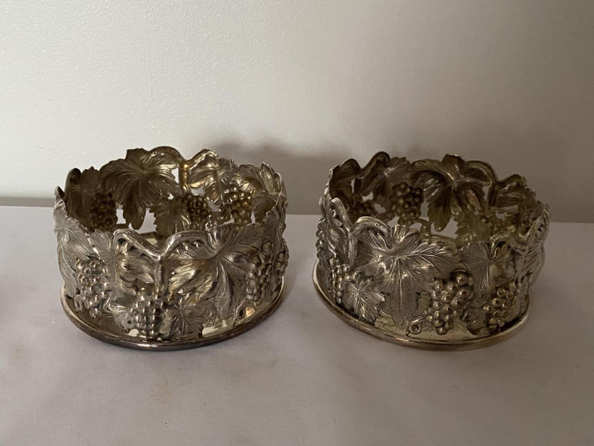 A PAIR OF PORTUGUESE TOPAZIO CASQUINHA ORNATE SILVER PLATED WINE COASTERS, T CROWN MARK AND DATE