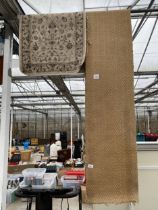 A SMALL CREAM PATTERNED RUG AND A CARPET RUNNER