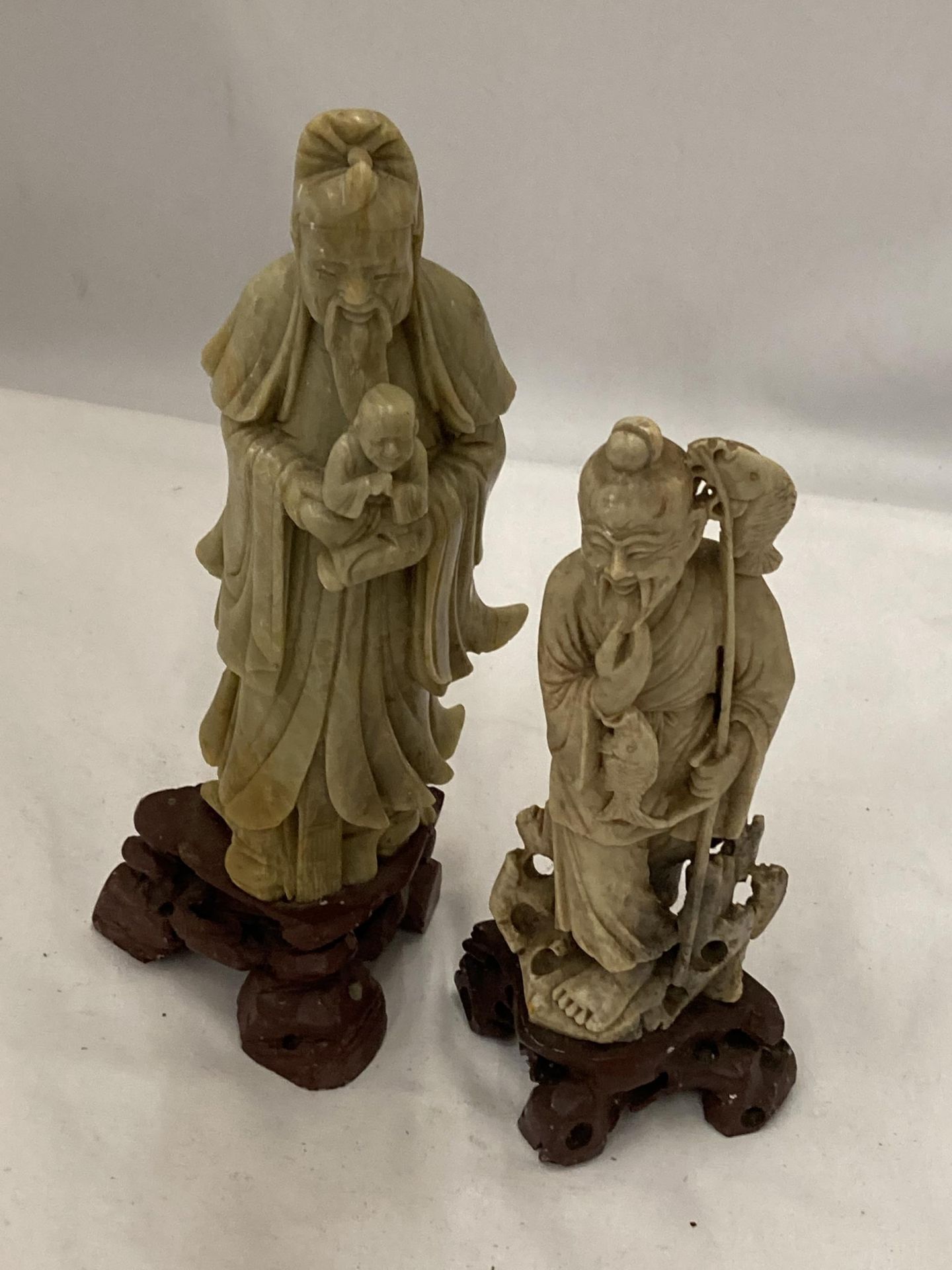 A PAIR OF CHINESE SOAPSTONE FIGURES ON WOODEN PLINTHS