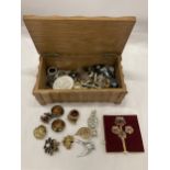 A WOODEN BOX CONTAINING A QUANTITY OF COSTUME JEWELLERY TO INCLUDE BROOCHES, BADGES, CUFFLINKS,