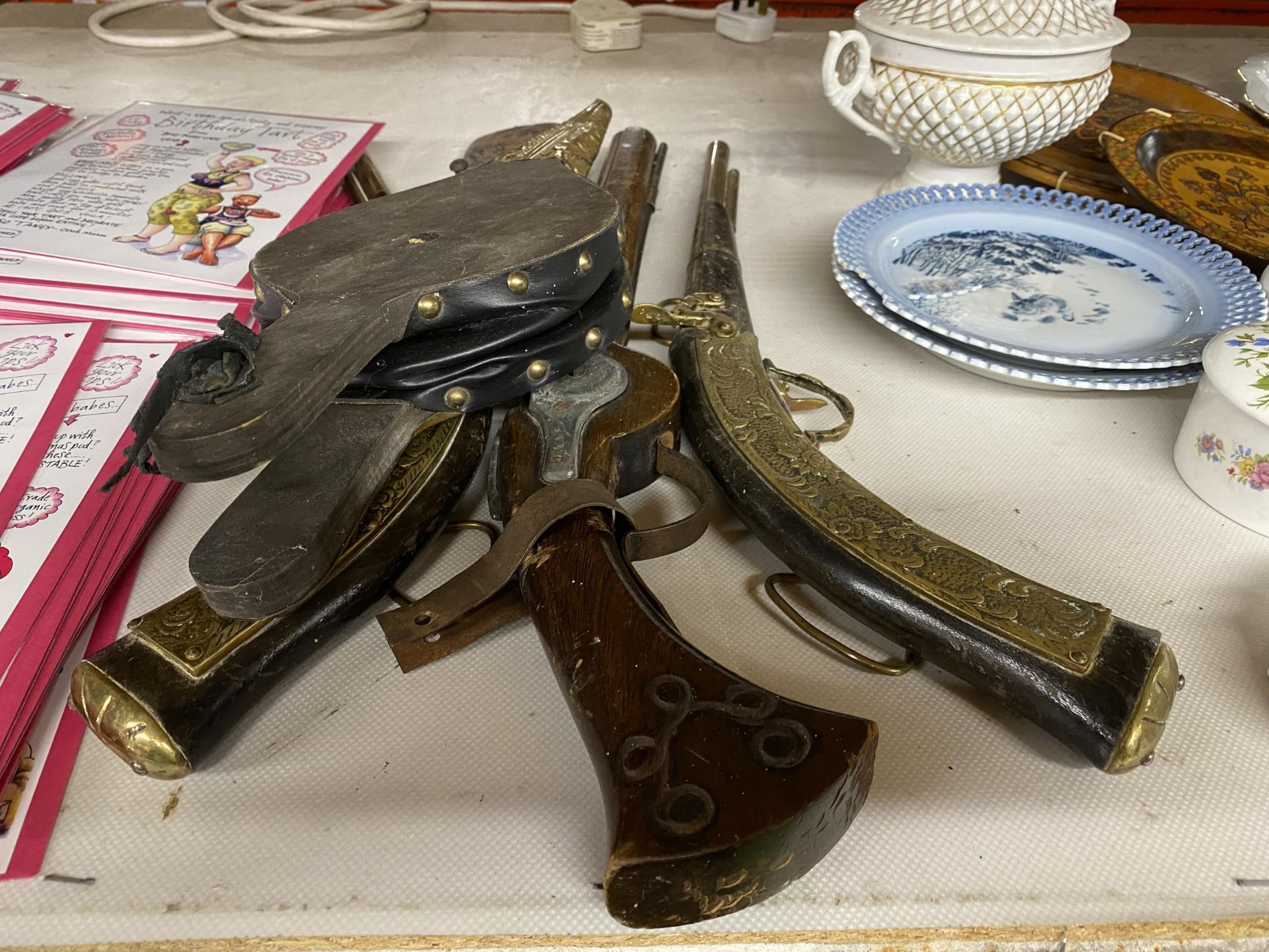 A GROUP OF THREE VINTAGE BRASS AND WOODEN DISPLAY GUNS, LEATHER POWDER FLASK AND BELLOWS