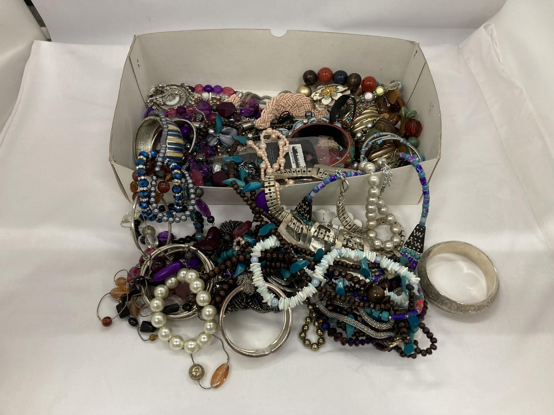 A QUANTITY OF COSTUME JEWELLERY TO INCLUDE BANGLES, NECKLACES, BRACELETS, ETC